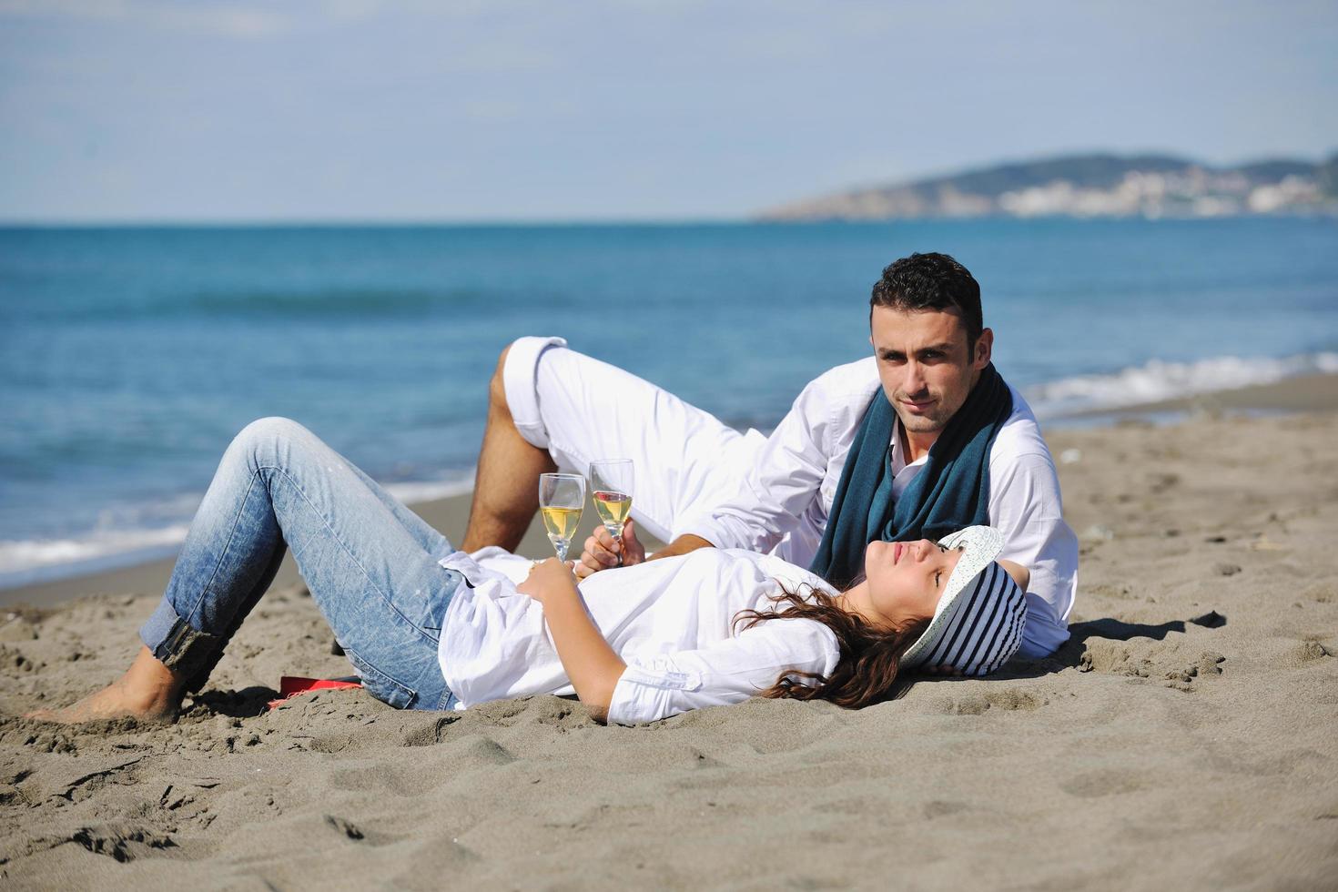 pareja joven disfrutando de un picnic en la playa foto