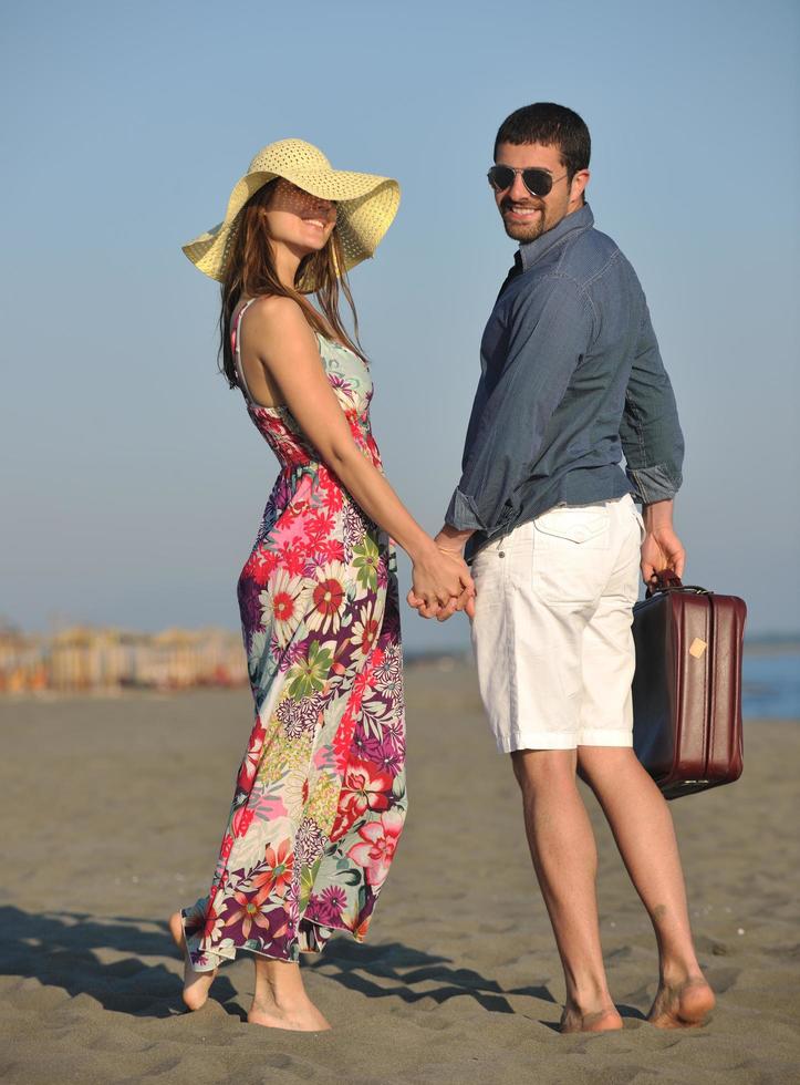 pareja en la playa con bolsa de viaje foto