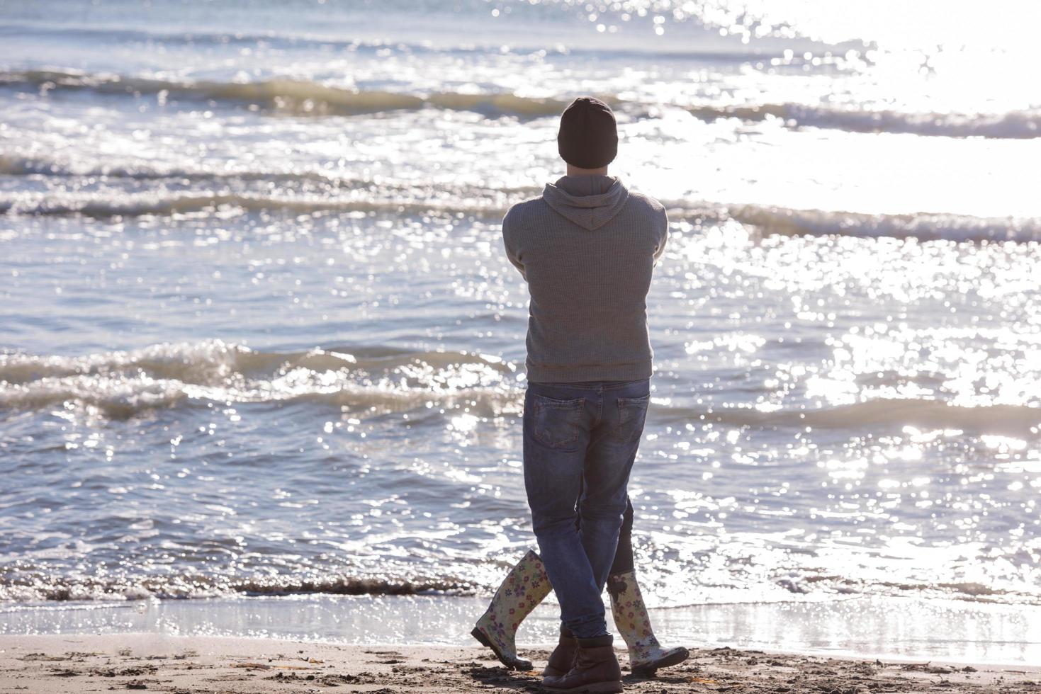 Loving young couple on a beach at autumn sunny day photo