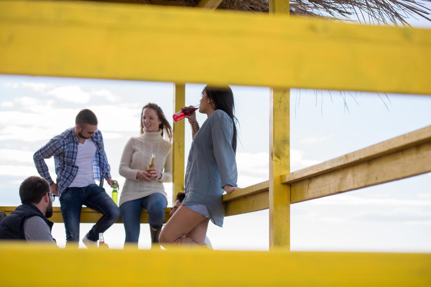 grupo de amigos divirtiéndose el día de otoño en la playa foto