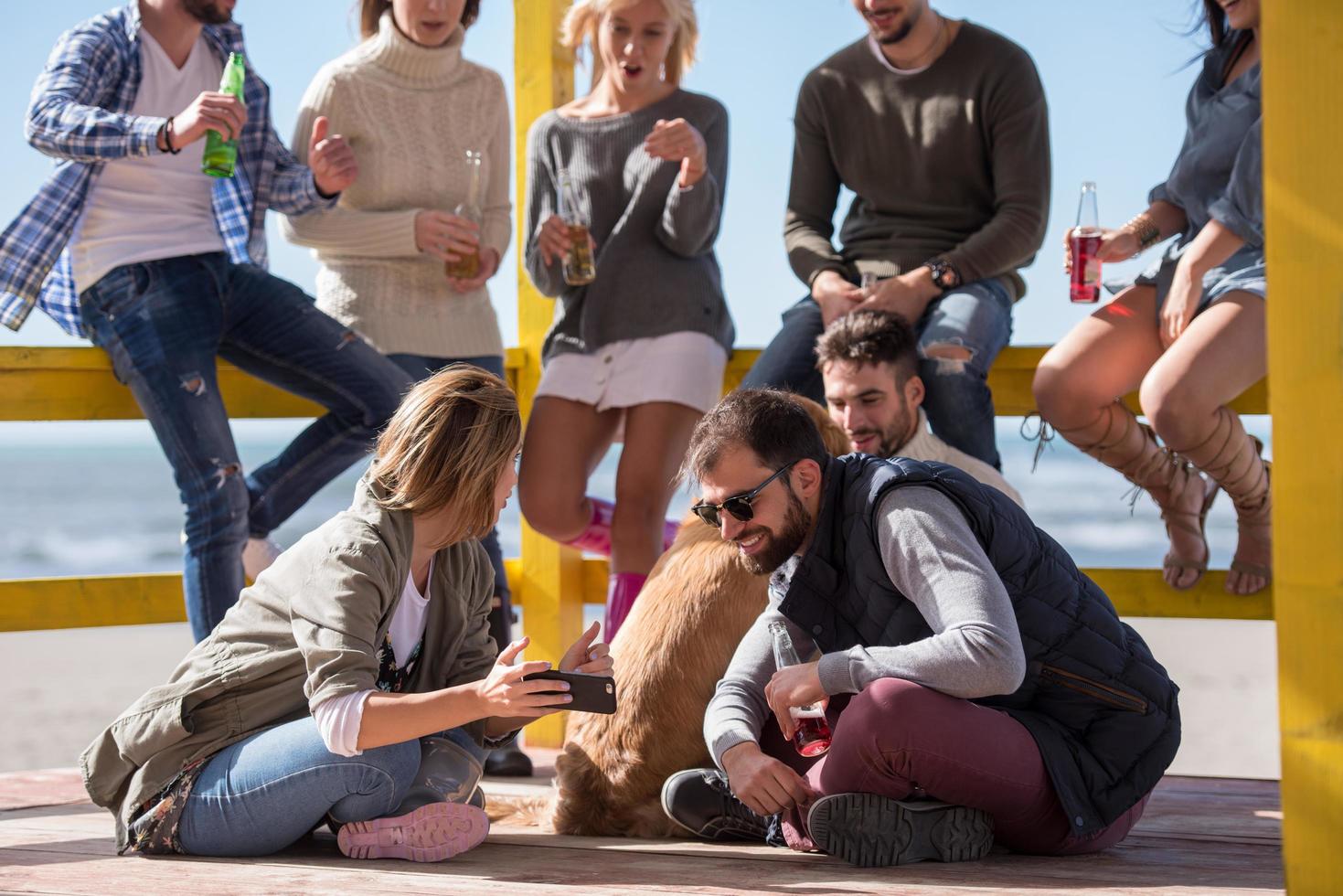 grupo de amigos divirtiéndose el día de otoño en la playa foto