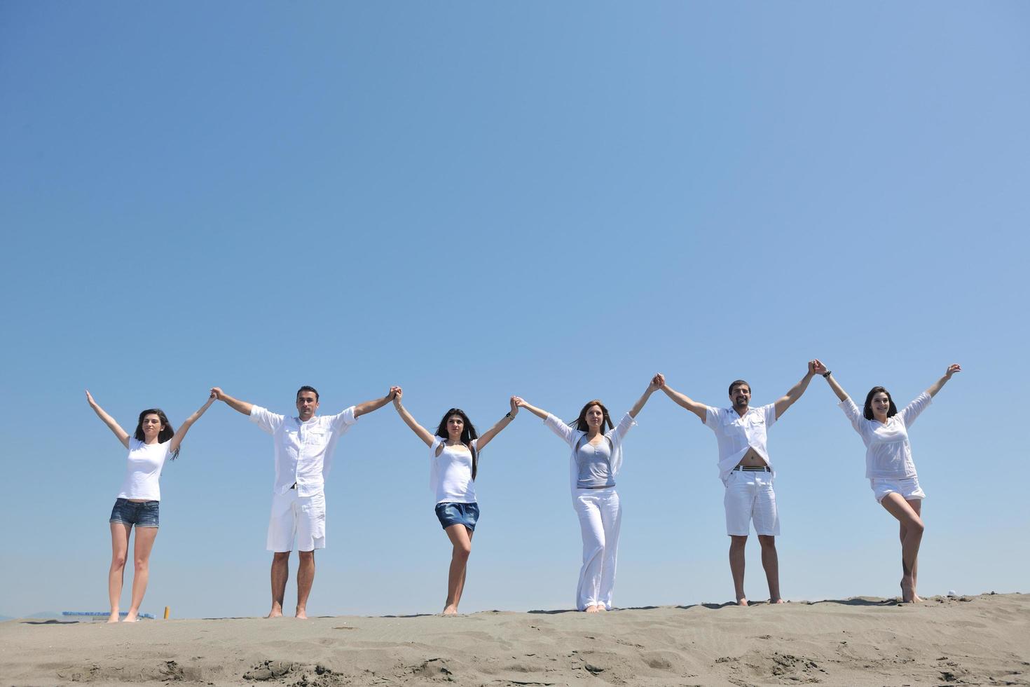 grupo de gente feliz divertirse y correr en la playa foto