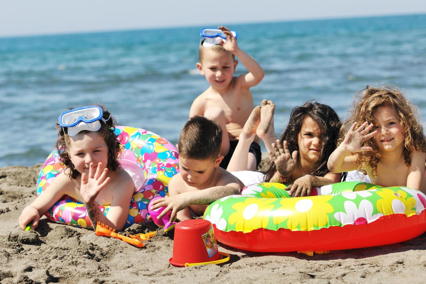 grupo infantil divertirse y jugar con juguetes de playa foto