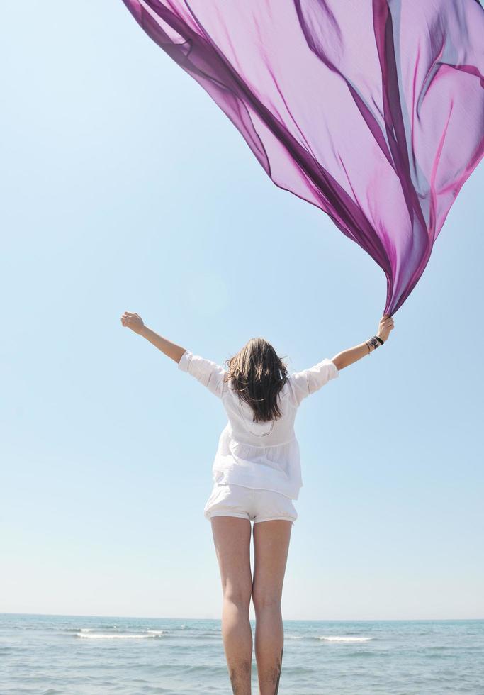 beautiful young woman on beach with scarf photo