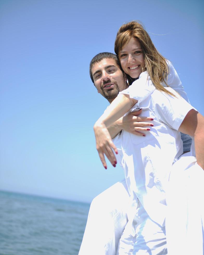 feliz pareja joven divertirse en la playa foto