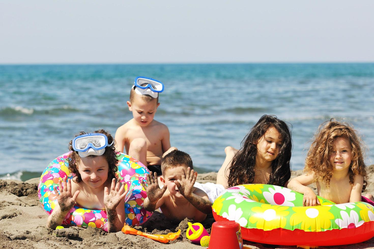 grupo infantil divertirse y jugar con juguetes de playa foto