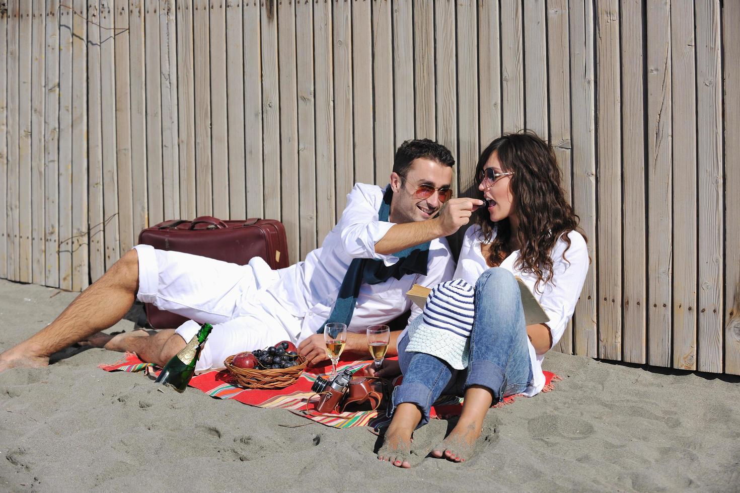 young couple enjoying  picnic on the beach photo