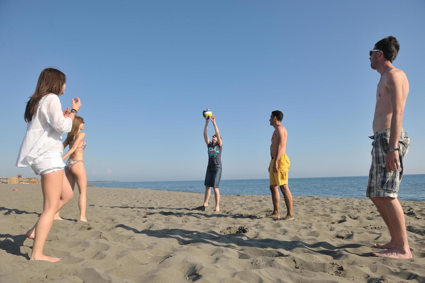 young people group have fun and play beach volleyball photo