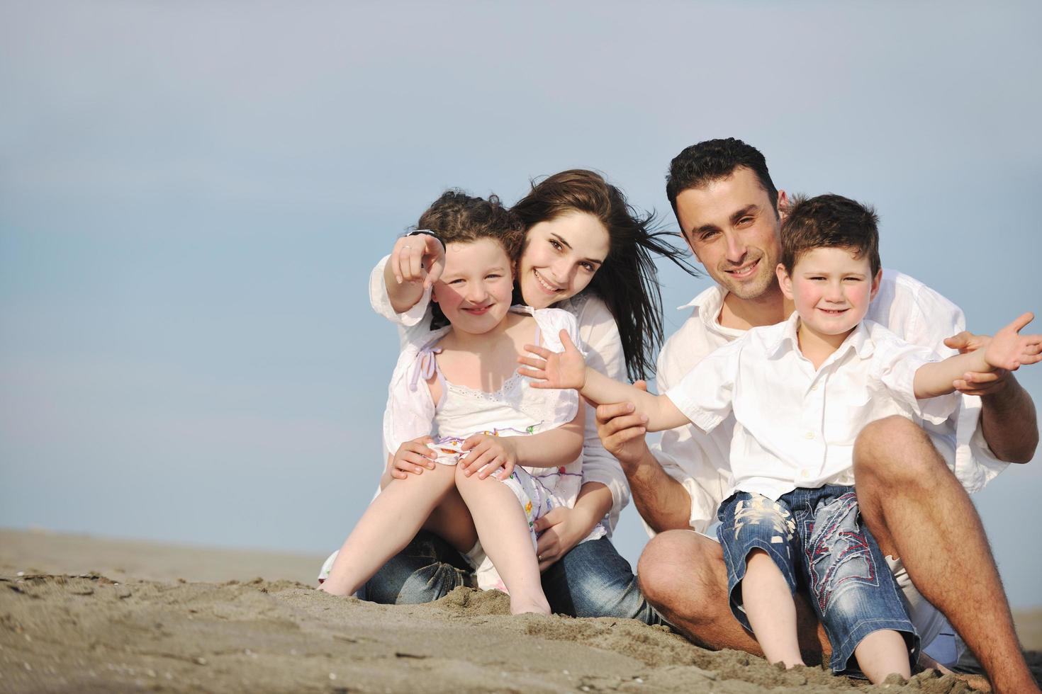 familia joven feliz divertirse en la playa foto