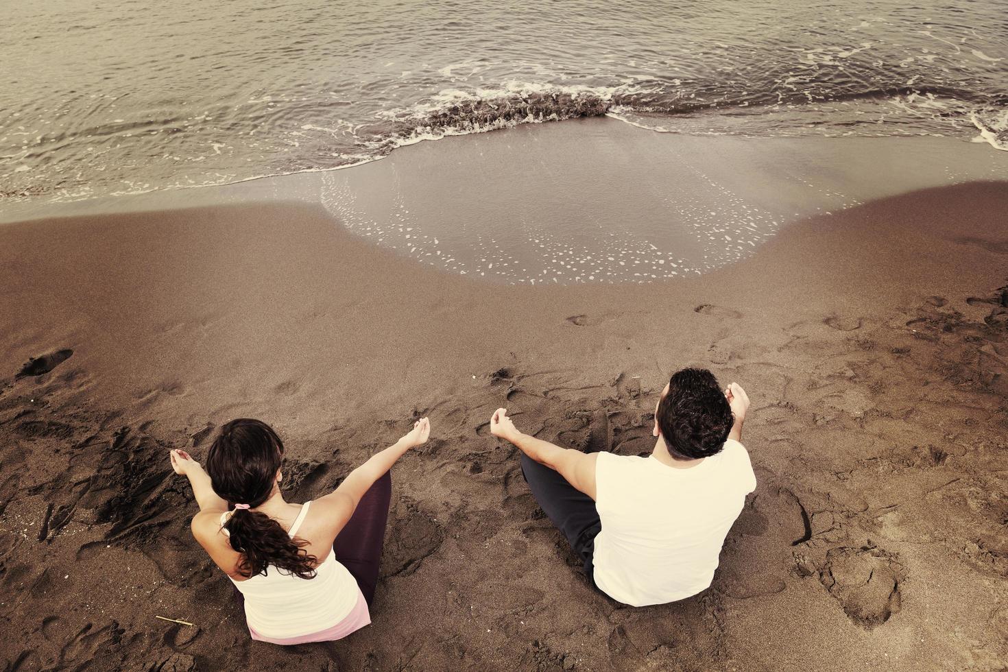 pareja yoga playa foto