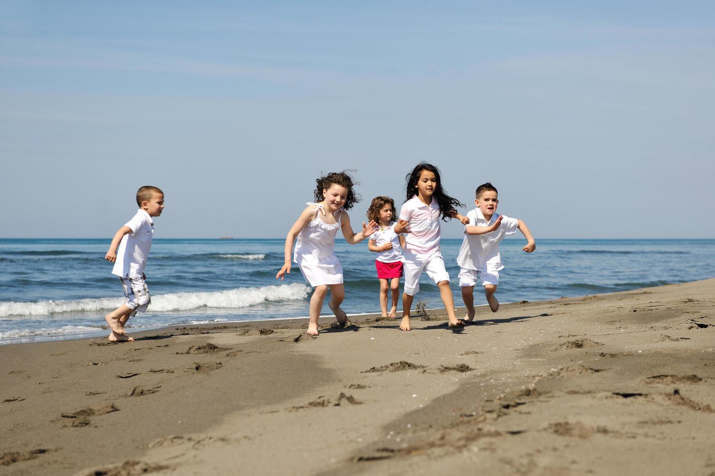 happy child group playing  on beach photo