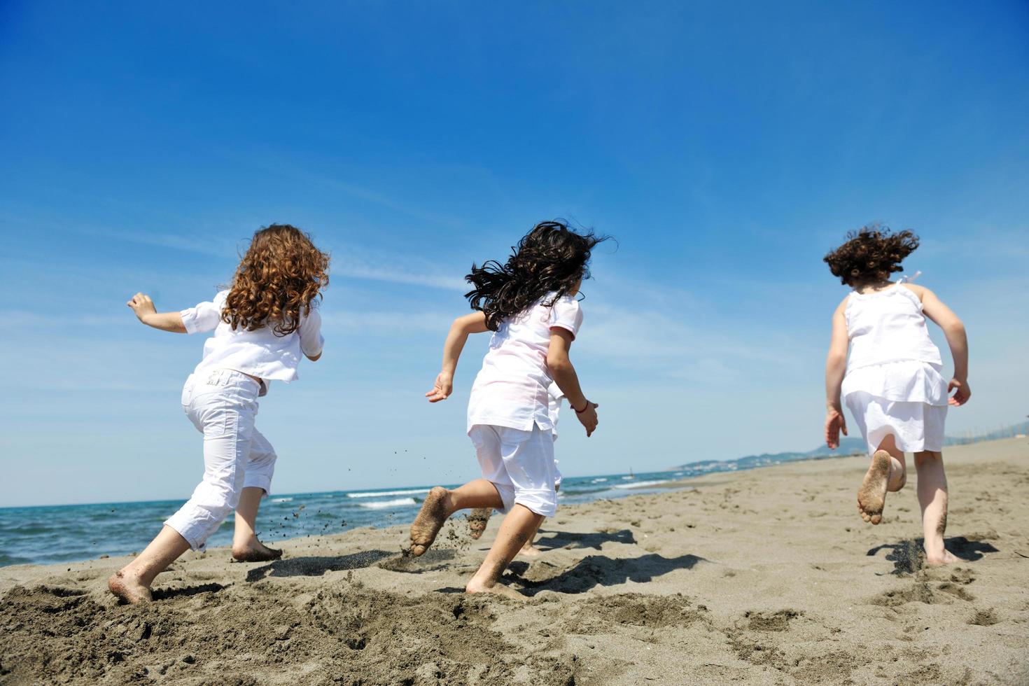 happy child group playing  on beach photo