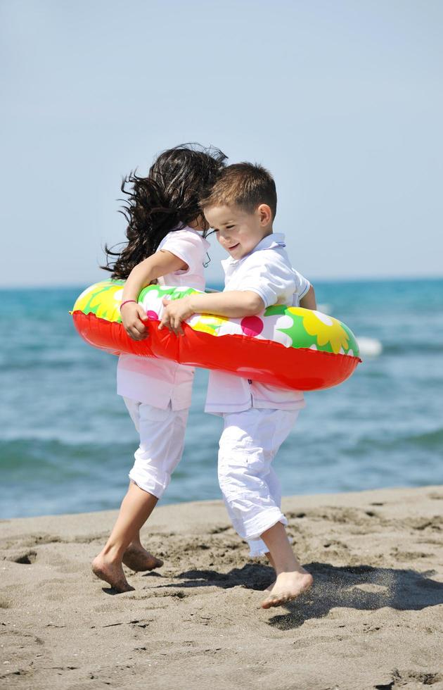 happy child group playing  on beach photo