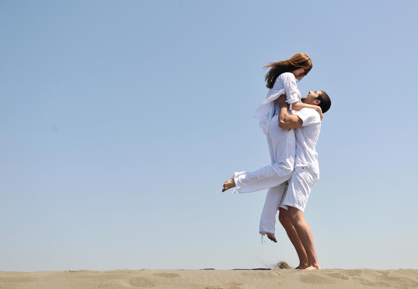 feliz pareja joven divertirse en la playa foto