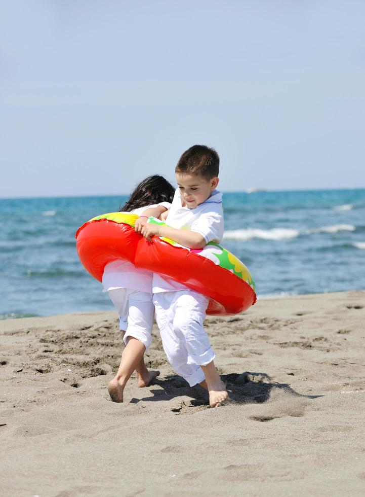 happy child group playing  on beach photo