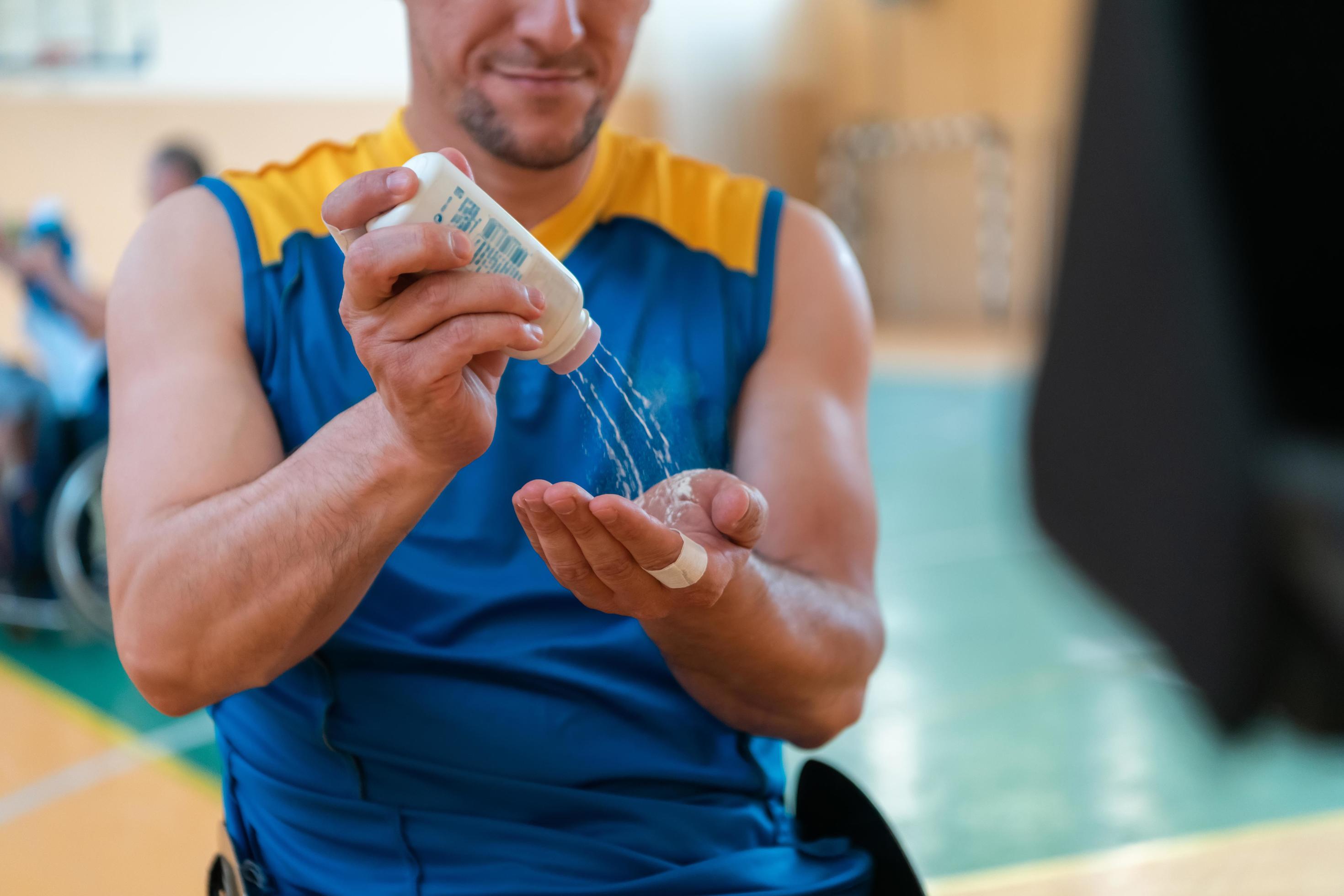 a basketball player puts antislip powder before the start of a
