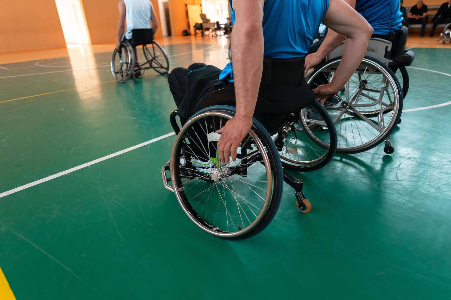 Close up photo of wheelchairs and handicapped war veterans playing basketball on the court