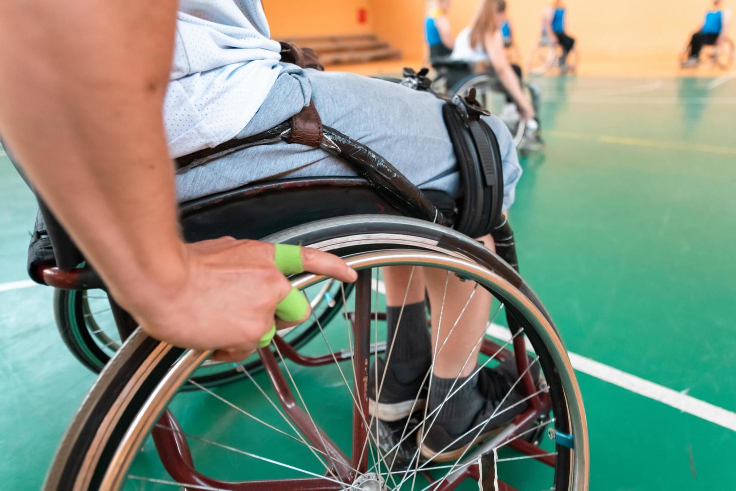 Close up photo of wheelchairs and handicapped war veterans playing basketball on the court