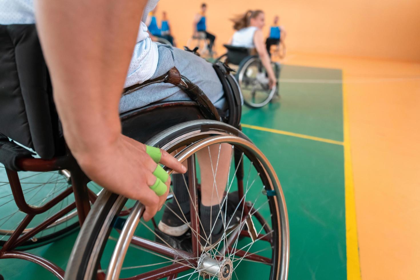 Close up photo of wheelchairs and handicapped war veterans playing basketball on the court