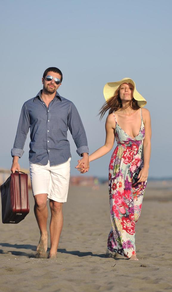 couple on beach with travel bag photo
