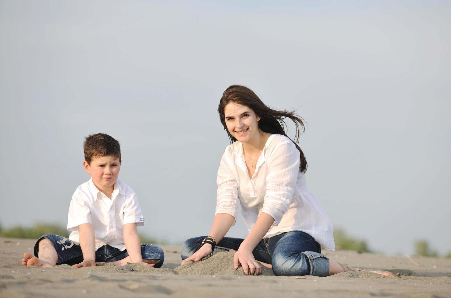 mom and son relaxing on beach photo