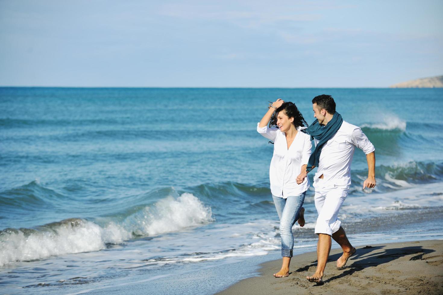 feliz pareja joven divertirse en la hermosa playa foto