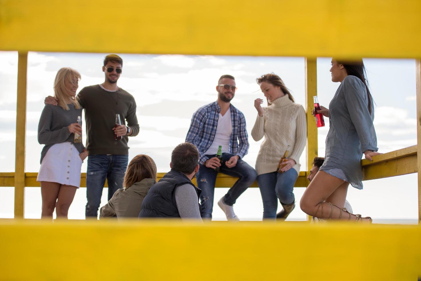 Group of friends having fun on autumn day at beach photo