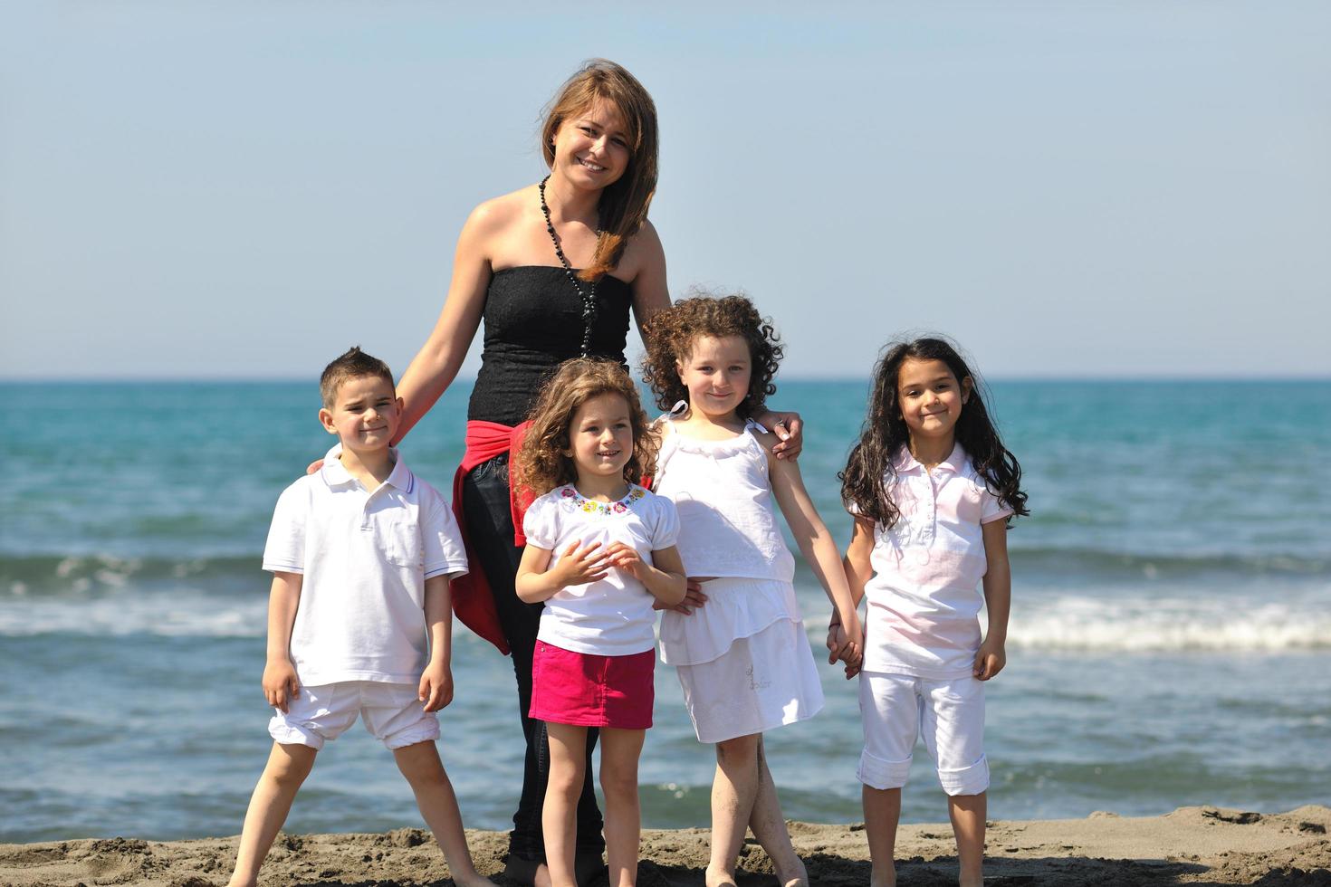 group portrait of childrens with teacher on beach photo