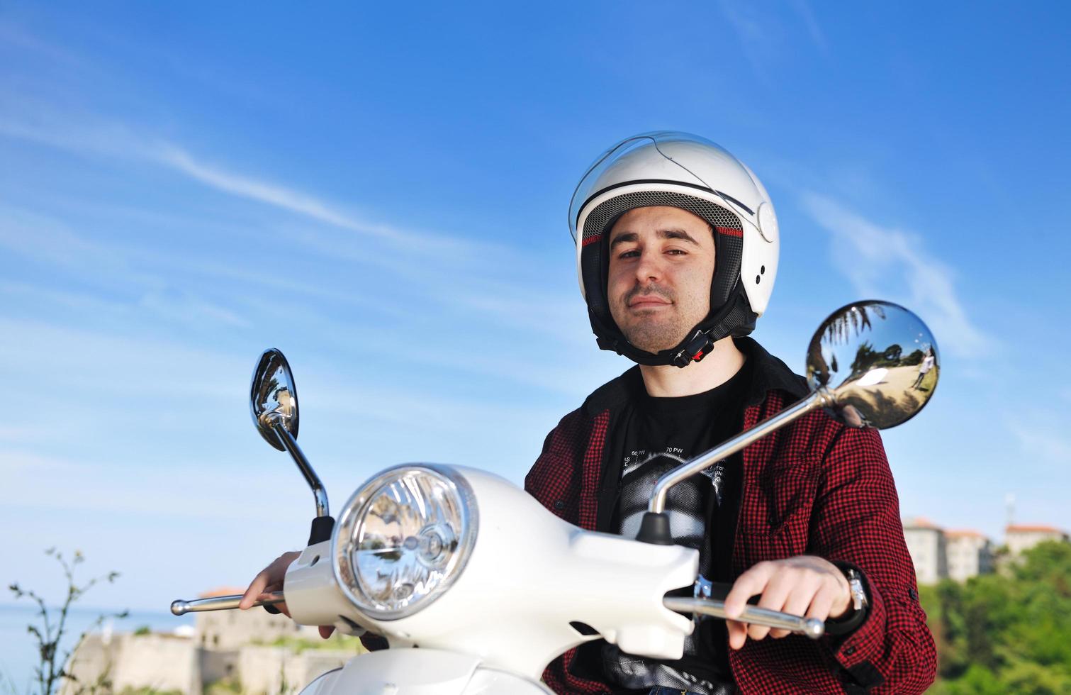 joven andar en scooter retro foto