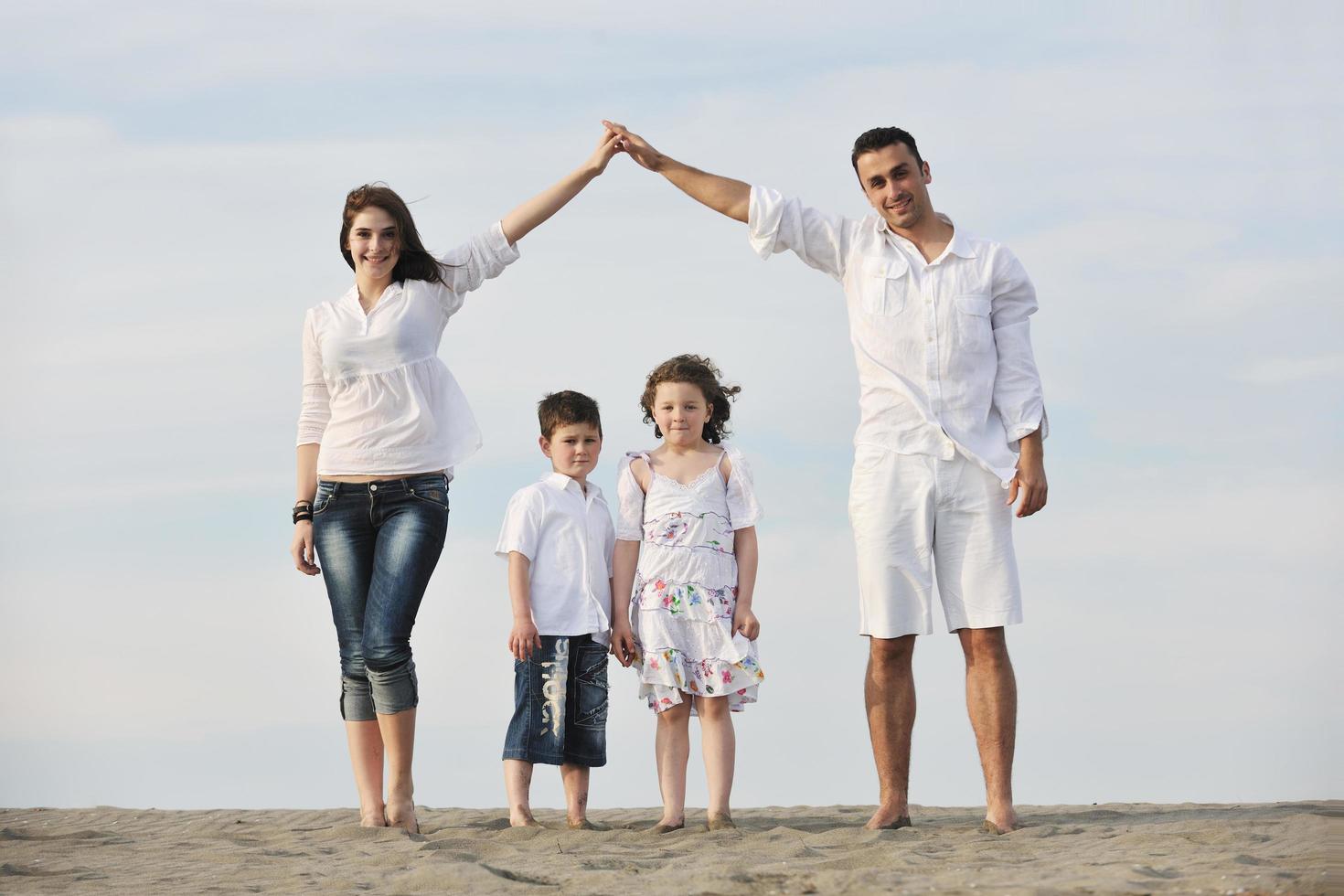 family on beach showing home sign photo