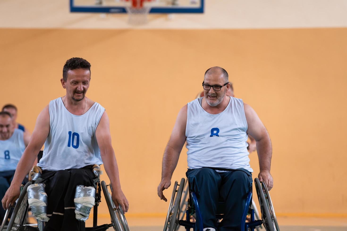 un equipo de veteranos de guerra en sillas de ruedas jugando baloncesto, celebrando los puntos ganados en un partido. choca esos cinco concepto foto