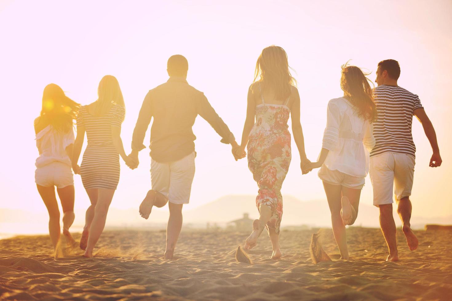 grupo de jóvenes felices divertirse en la playa foto