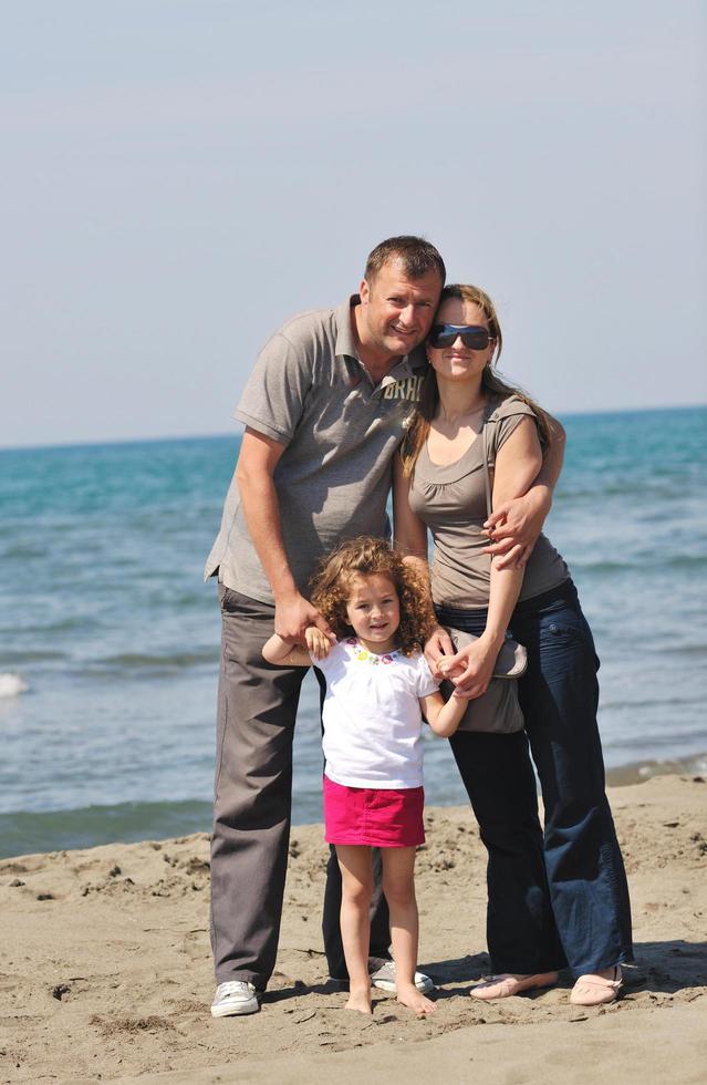 familia joven feliz divertirse en la playa foto