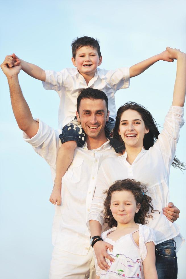 familia joven feliz divertirse en la playa foto