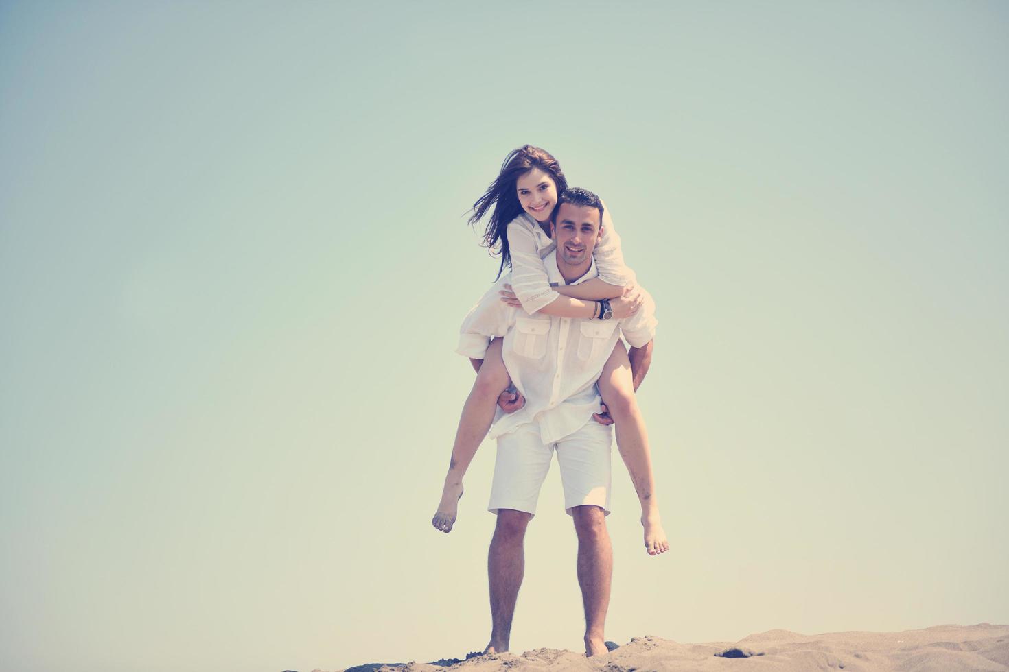 feliz pareja joven divertirse en la playa foto