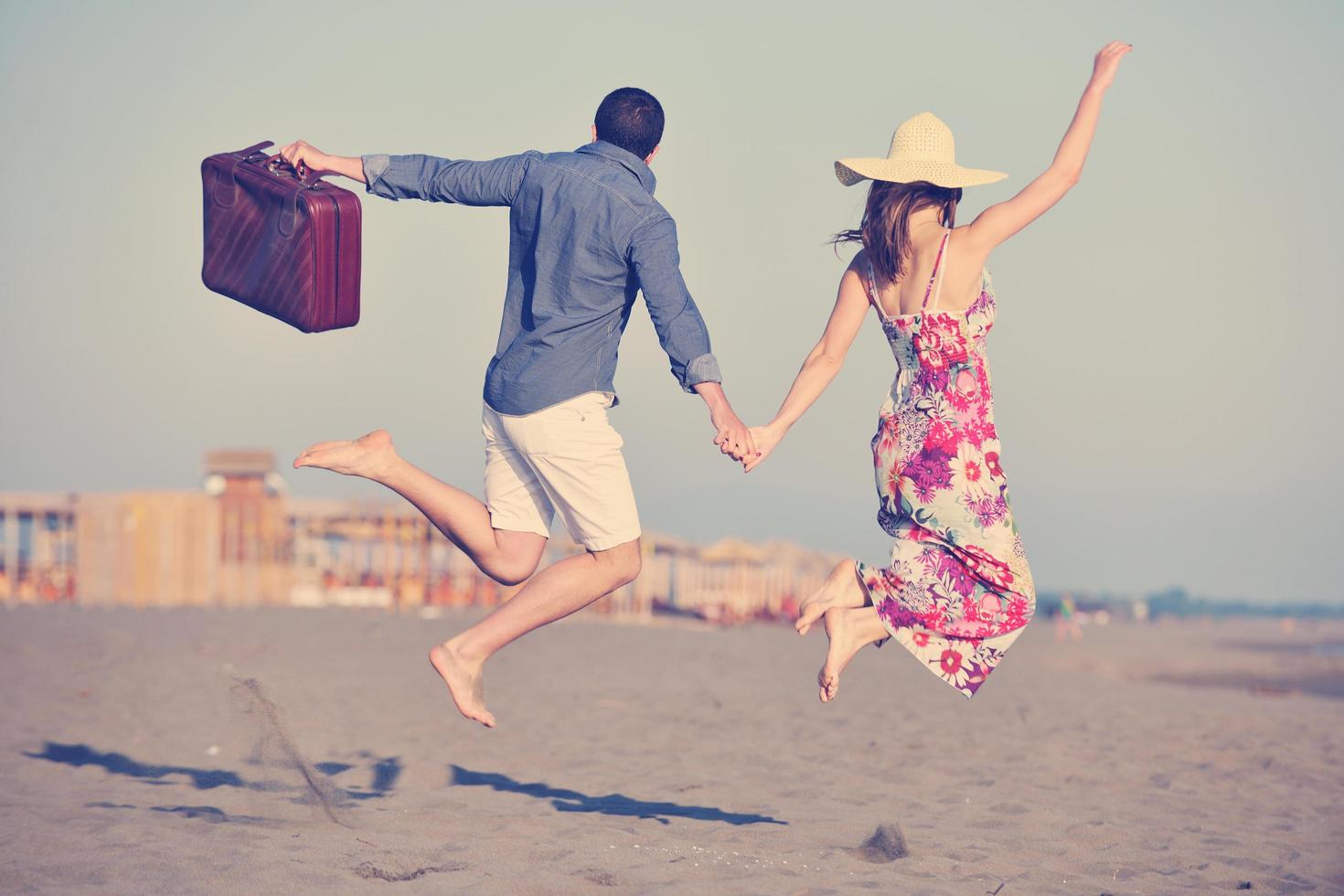 couple on beach with travel bag photo