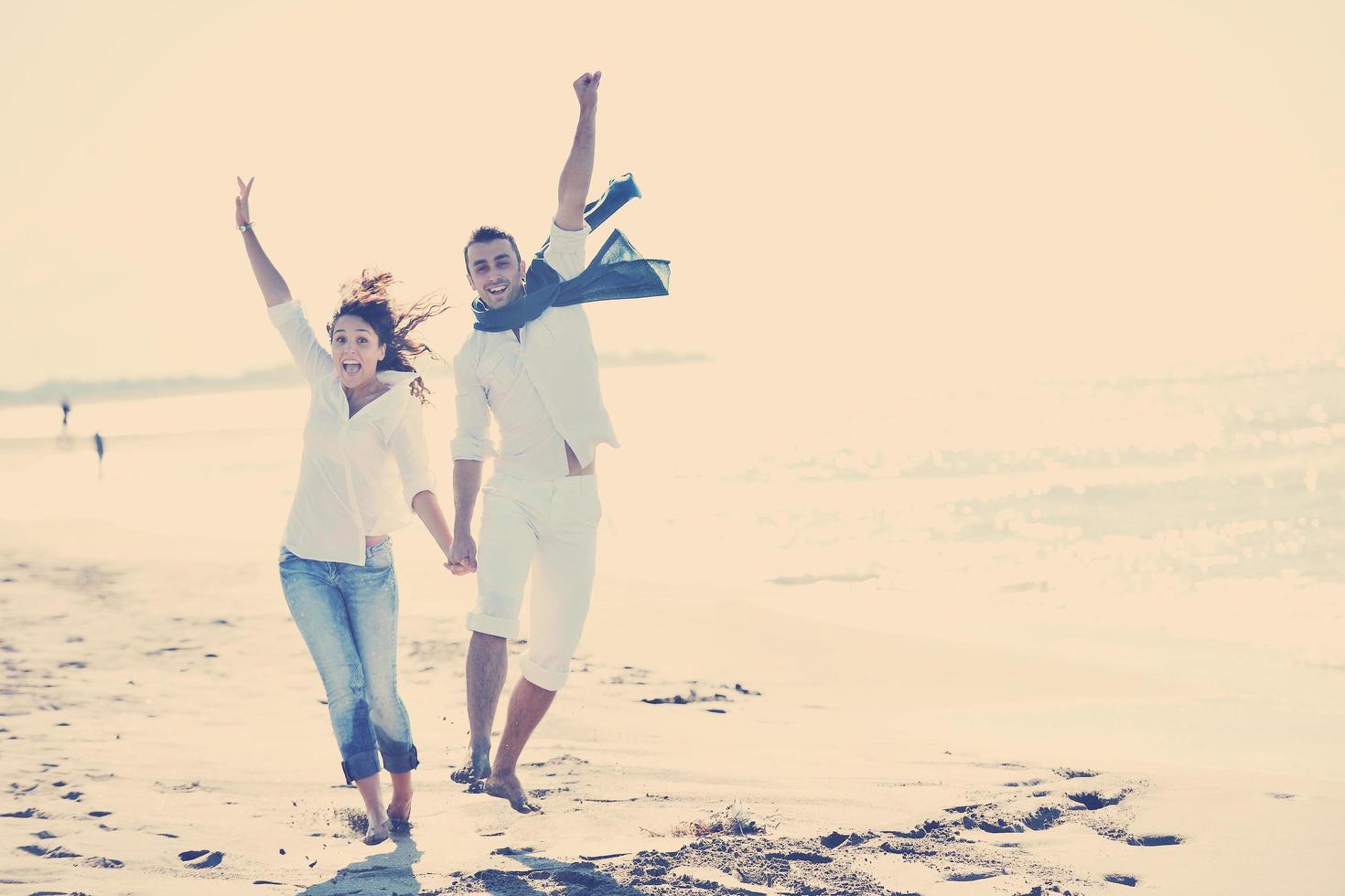 feliz pareja joven divertirse en la hermosa playa foto