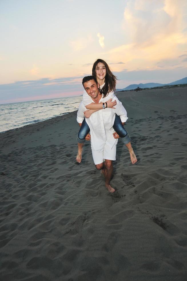 feliz pareja joven divertirse en la playa foto