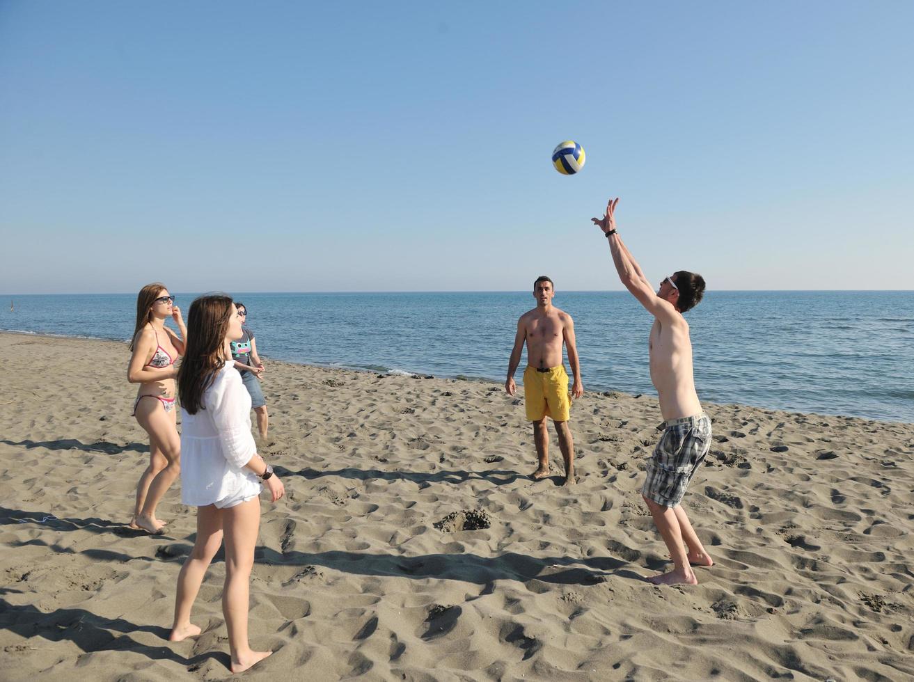 young people group have fun and play beach volleyball photo