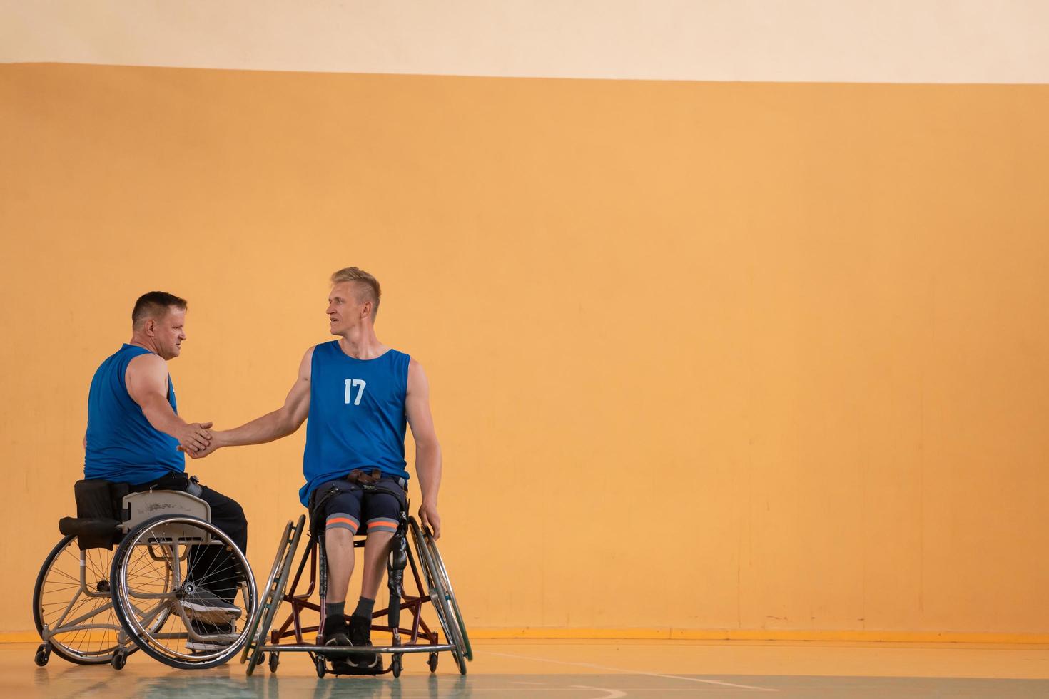 un equipo de veteranos de guerra en sillas de ruedas jugando baloncesto, celebrando los puntos ganados en un partido. choca esos cinco concepto foto