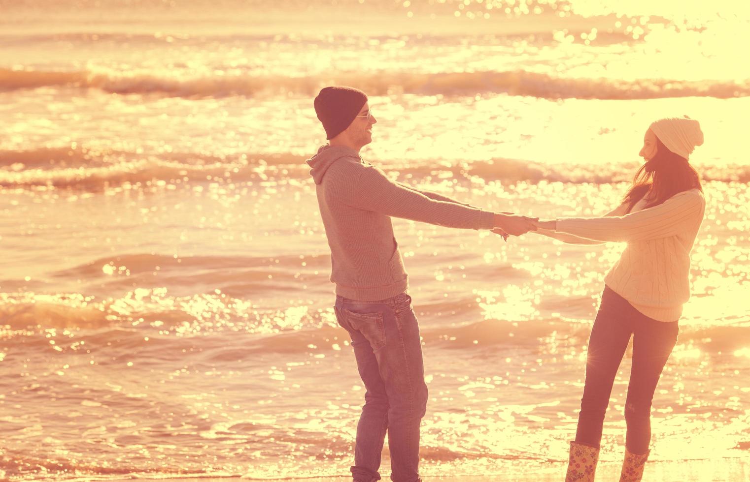 amorosa pareja joven en una playa en el día soleado de otoño foto