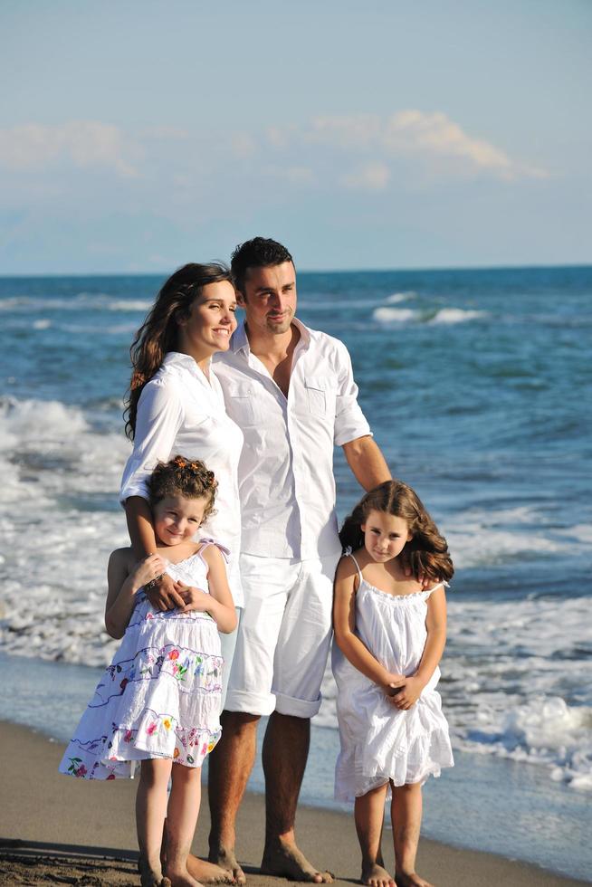 familia joven feliz divertirse en la playa foto