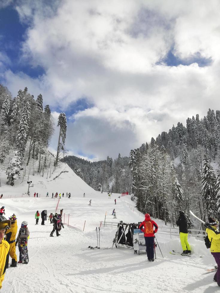 gente de esquí. pista de esquí en montañas y bosques, actividad invernal, esquiadores y practicantes de snowboard en la estación de esquí foto