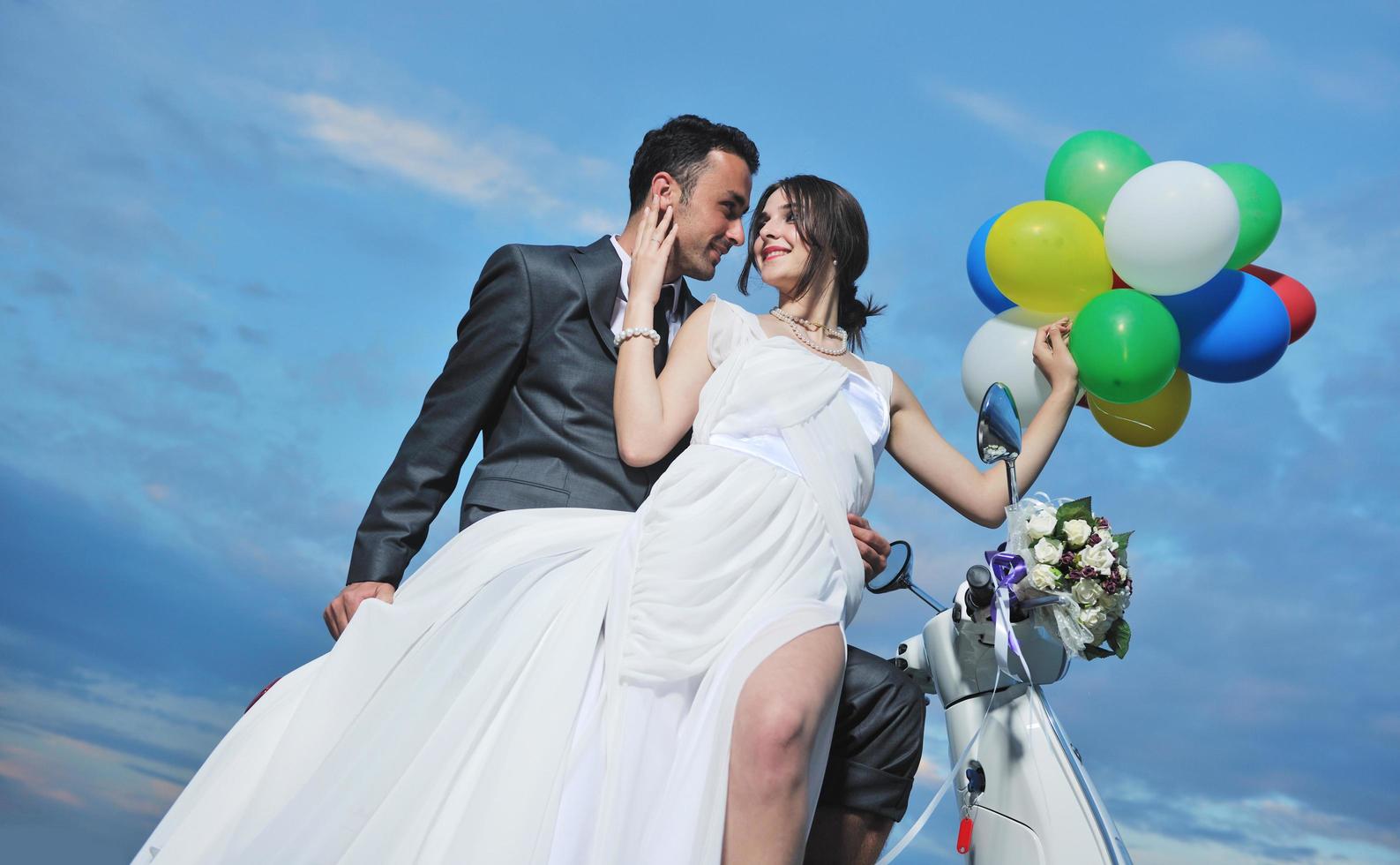 just married couple on the beach ride white scooter photo