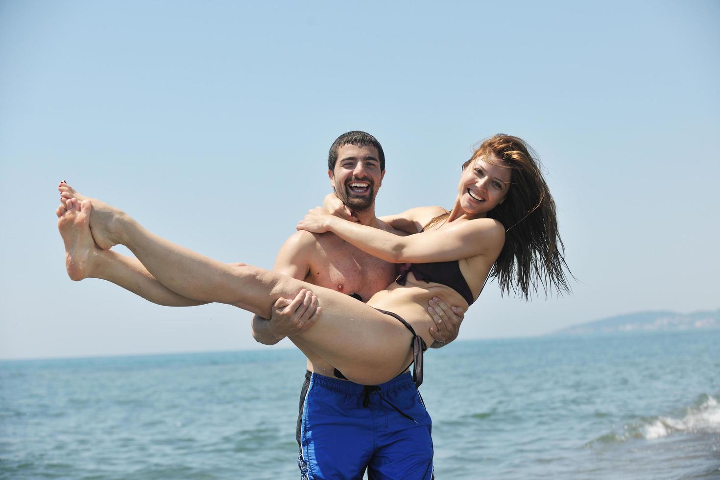 happy young couple have fun on beach photo