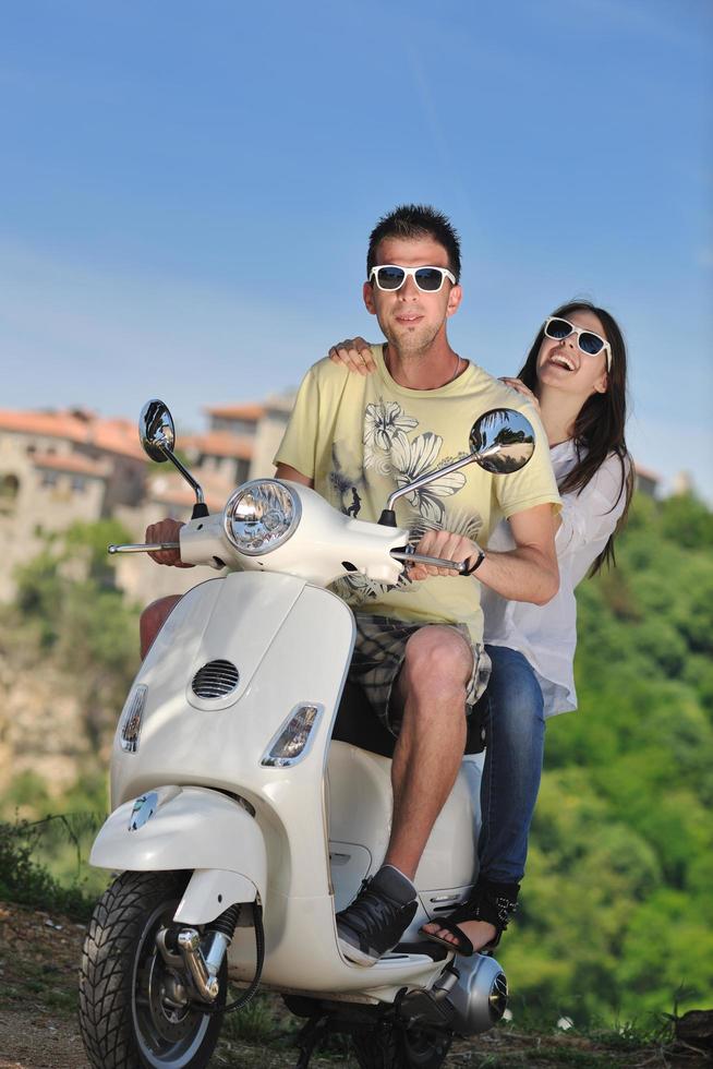 Portrait of happy young love couple on scooter enjoying summer time photo