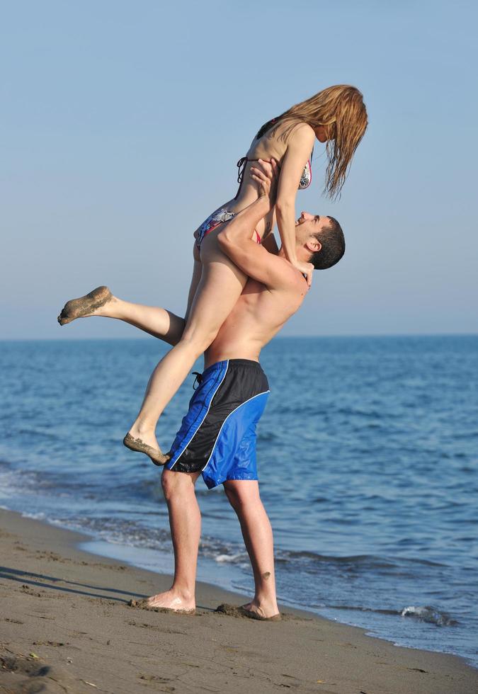 feliz pareja joven tiene tiempo romántico en la playa foto