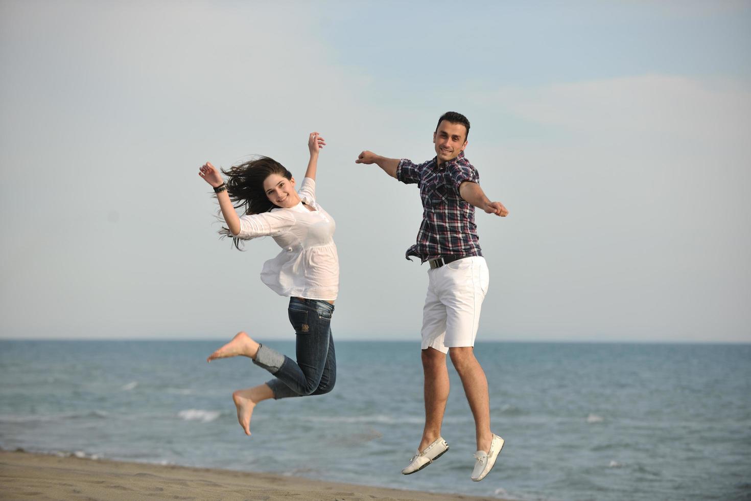 happy young couple have fun on beach photo