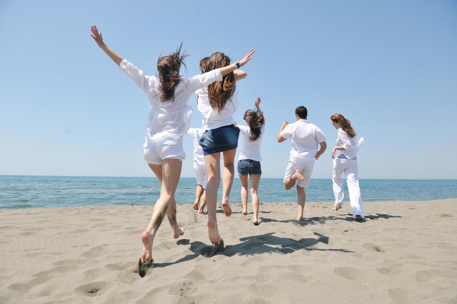 happy people group have fun and running on beach photo