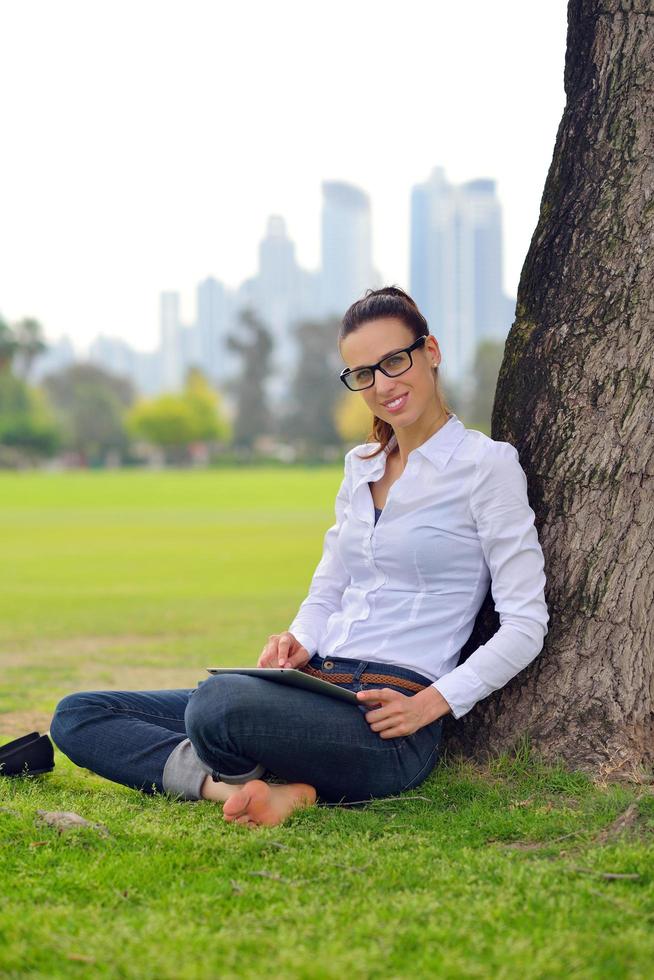 Beautiful young woman with  tablet in park photo